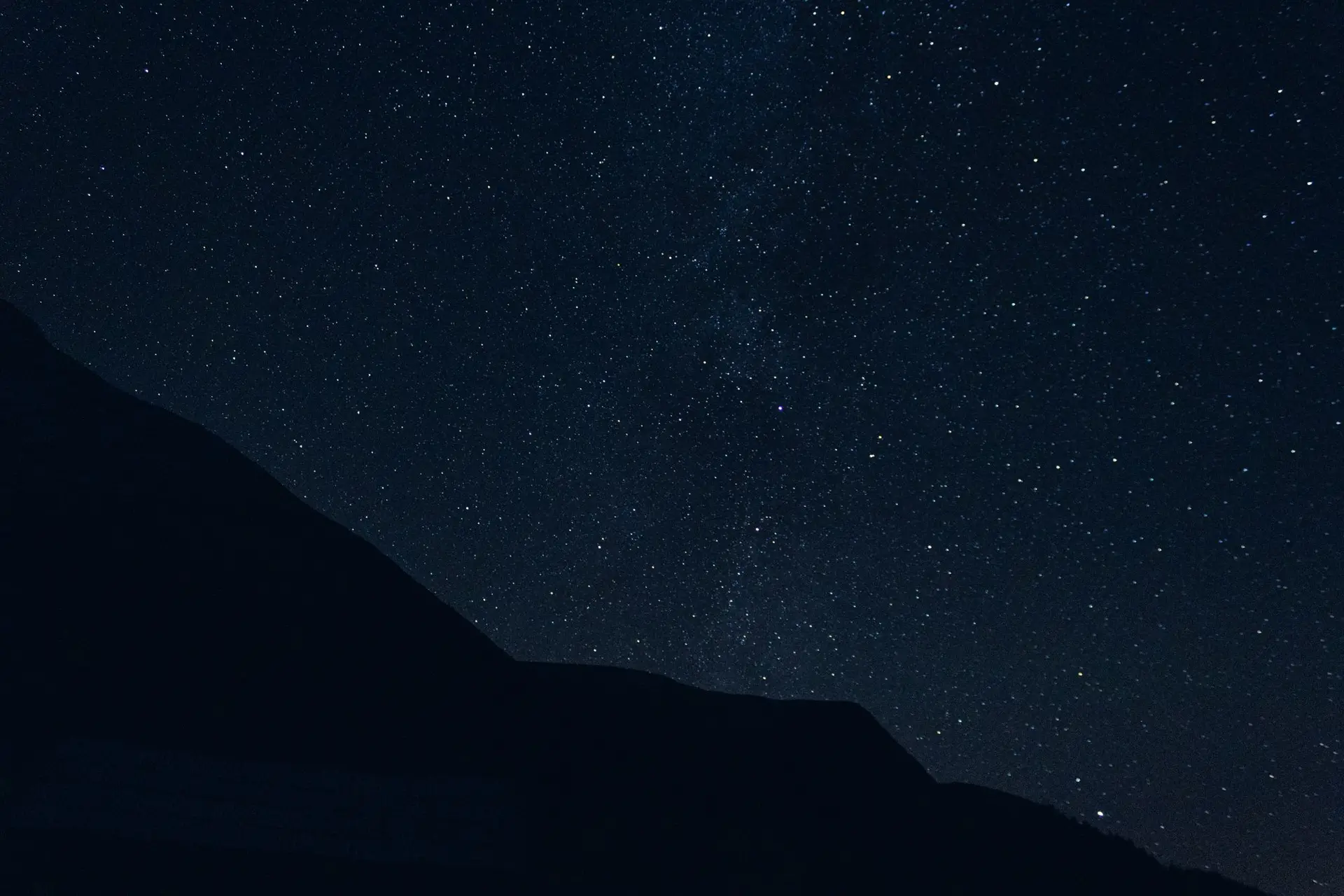 Star-filled sky over dark mountain silhouettes at Holda, Suceava, Romania.